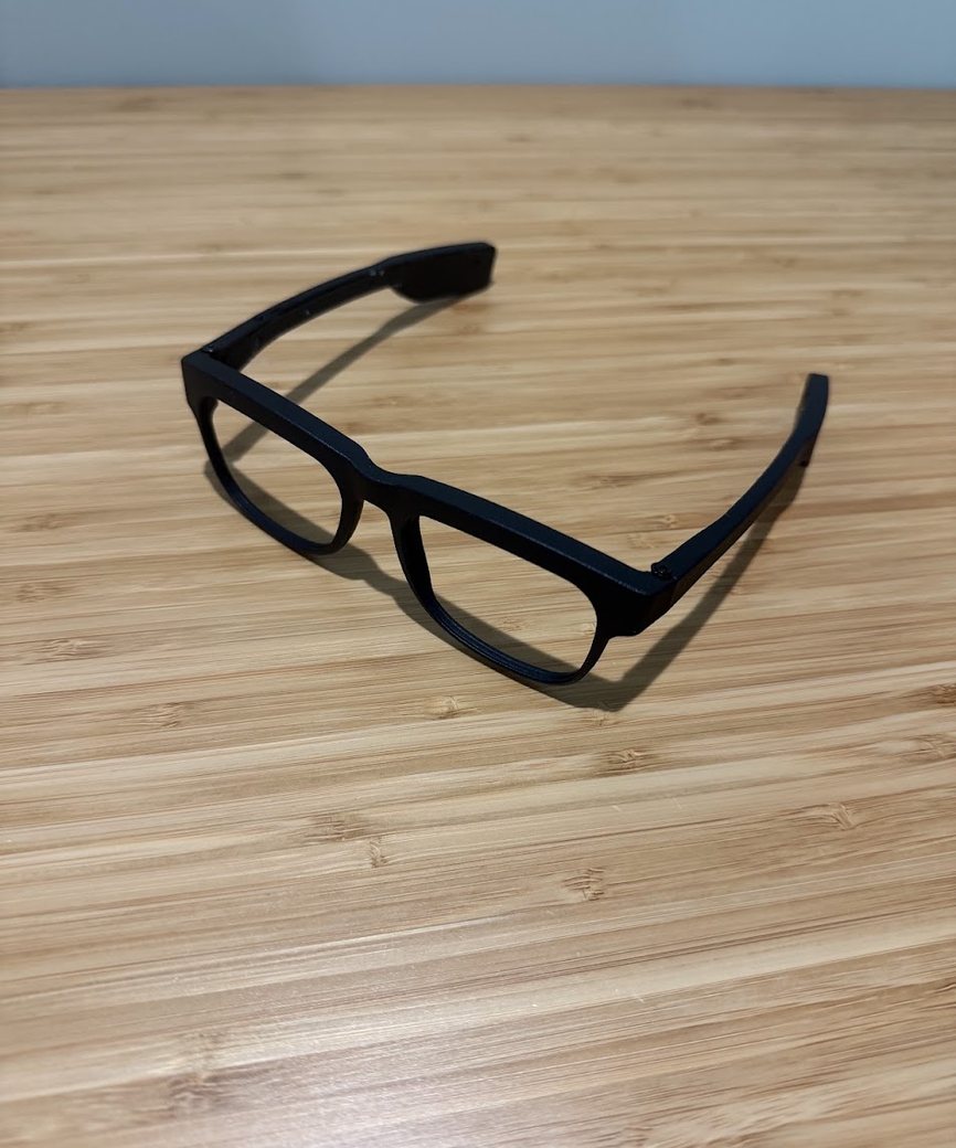 Prototype light-therapy glasses resting on a wooden table